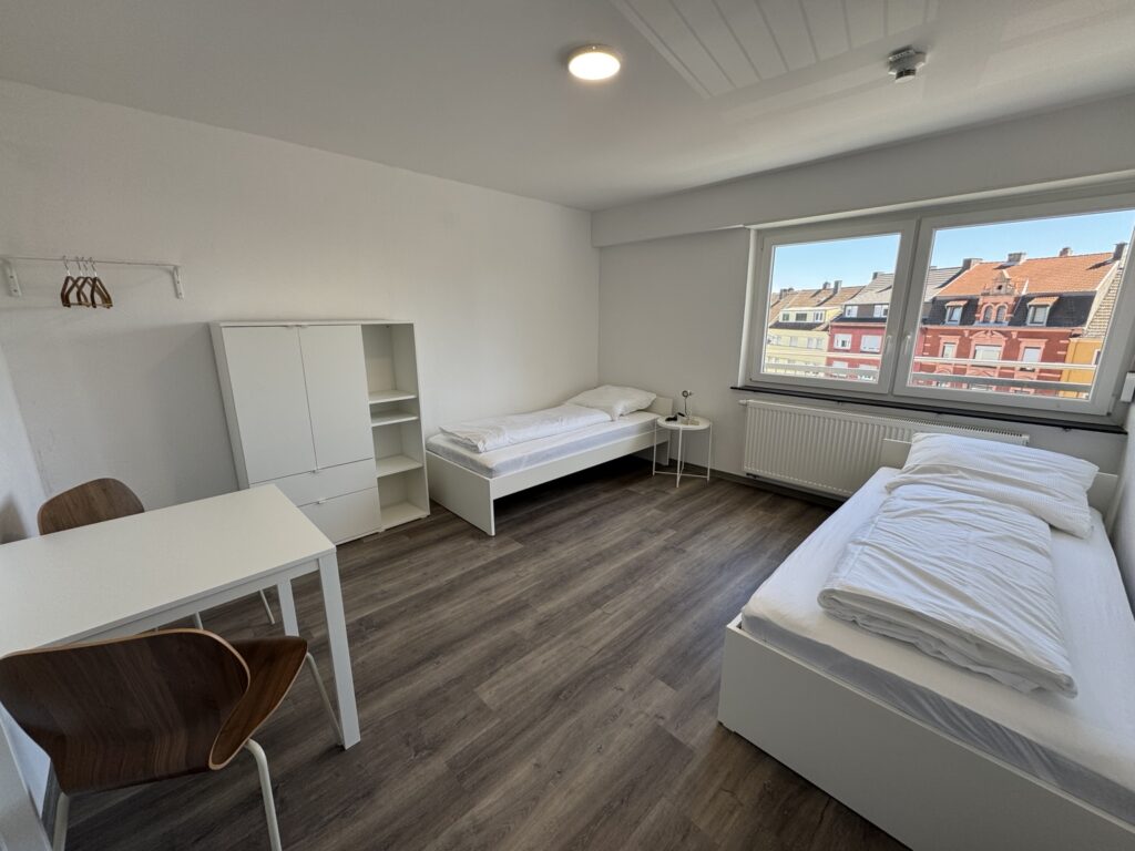 Schlafzimmer mit Einzelbetten in der 8-Personen-Wohnung 4 im Haus Burgkeller