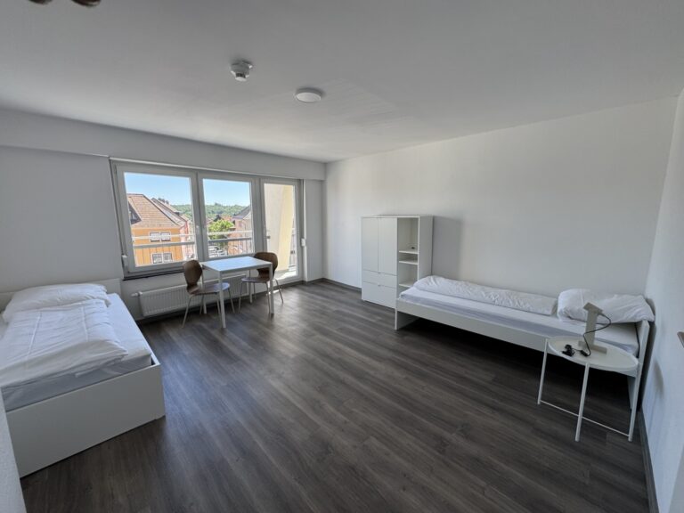 Schlafzimmer mit Einzelbetten in der 8-Personen-Wohnung 4 im Haus Burgkeller