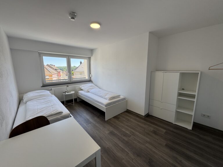 Schlafzimmer mit Einzelbetten in der 8-Personen-Wohnung 4 im Haus Burgkeller